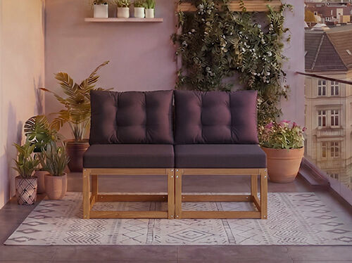 Dvojmiestna modul&aacute;rna dreven&aacute; sedačka s tmavosiv&yacute;mi vank&uacute;&scaron;mi na balk&oacute;ne obklopenom kvetin&aacute;čov&yacute;mi rastlinami a v&yacute;hľadom na mesto v pozad&iacute;