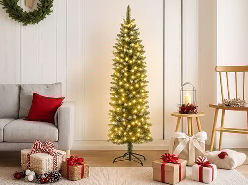 Svetlá, moderná sviatočná scéna s vysokým, štíhlym, predosvetleným vianočným stromčekom s teplými bielymi svetlami, stojacim v strede. Vľavo je vidieť opierku a chrbát svetlosivej pohovky s červeným vankúšom. Kolekcia zabalených darčekov, previazaných červenými a bielymi stuhami a ozdobených šiškami, leží na svetlom koberci v popredí. Vpravo sa nachádza drevená stolička a malý okrúhly drevený stolík s lampášom a sviečkou, ktoré dotvárajú útulnú, sviatočnú atmosféru.